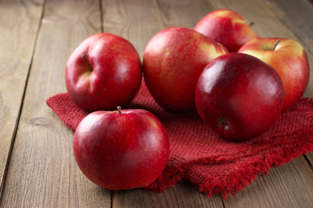 42689574 – red apples with linen napkin on rustic wooden table.